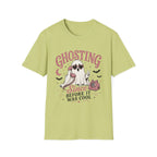A light yellow-green crewneck t-shirt with a Halloween-themed graphic on the front. The graphic features the word 'GHOSTING' in pink arched letters above a cartoon ghost wearing sunglasses, a pink cat, bats, and the text 'Since BEFORE IT WAS COOL' in black and pink.