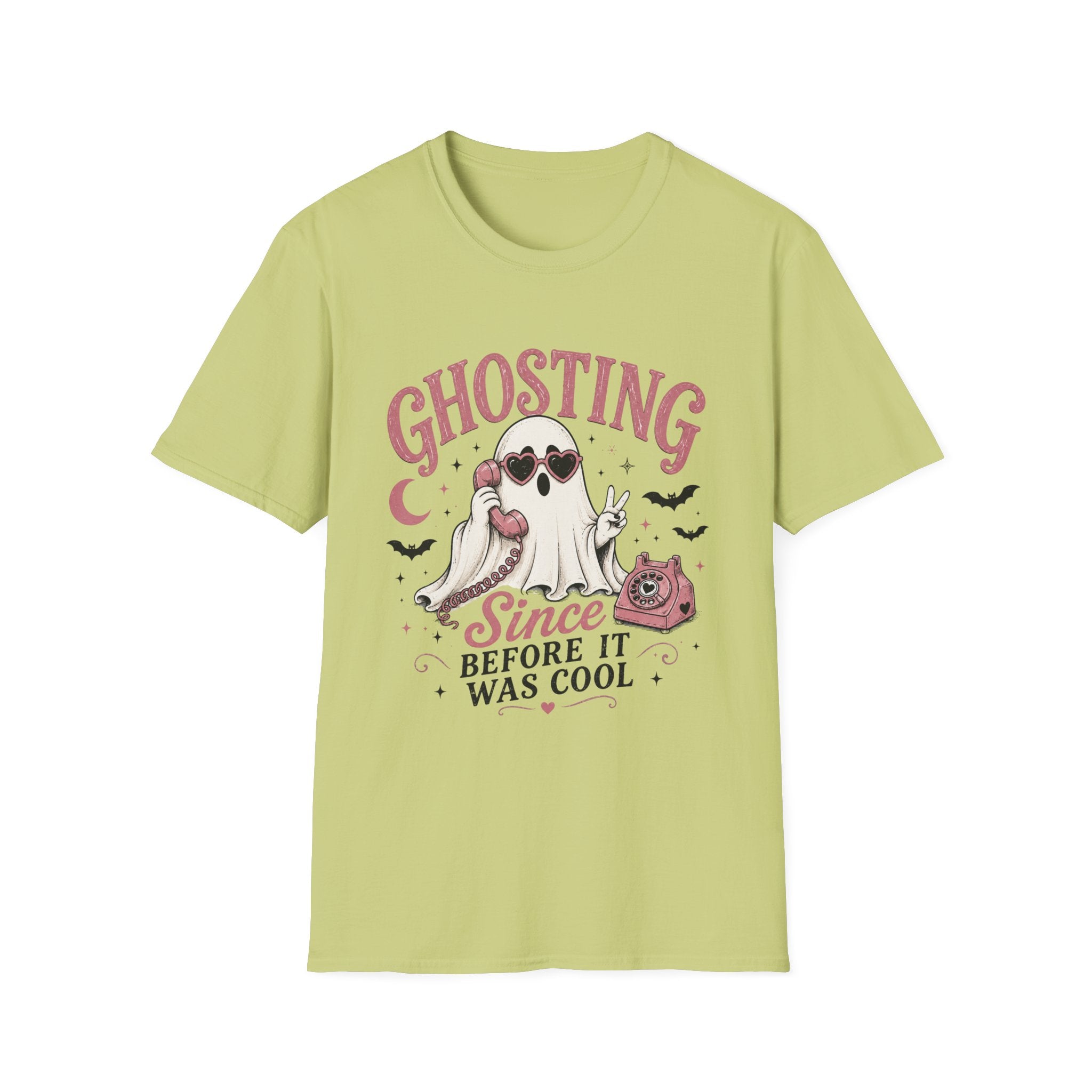 A light yellow-green crewneck t-shirt with a Halloween-themed graphic on the front. The graphic features the word 'GHOSTING' in pink arched letters above a cartoon ghost wearing sunglasses, a pink cat, bats, and the text 'Since BEFORE IT WAS COOL' in black and pink.