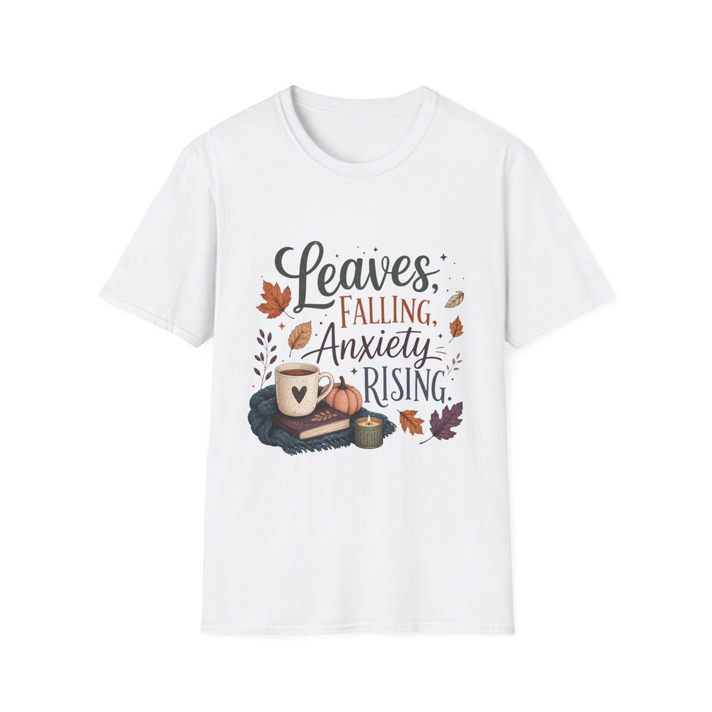 A white short-sleeve crewneck t-shirt featuring a graphic print with the text 'Leaves, Falling, Anxiety Rising' in a mix of black and reddish-brown fonts, surrounded by autumn-themed illustrations including leaves, a mug, a pumpkin, and a candle.