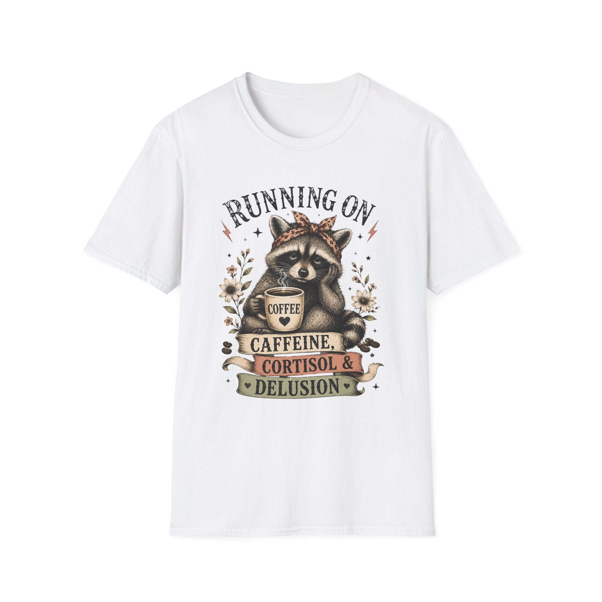 A white short-sleeve crewneck t-shirt featuring a graphic print of a raccoon wearing a crown and holding a coffee mug, surrounded by the text 'RUNNING ON CAFFEINE, CORTISOL & DELUSION'.