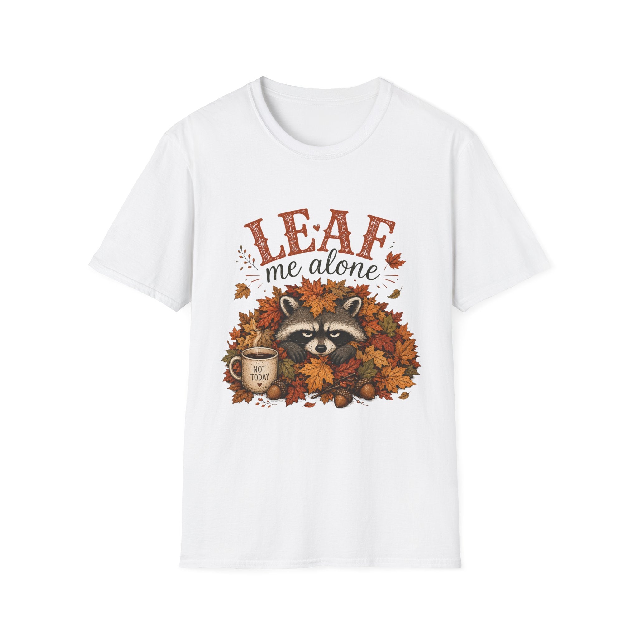 A white short-sleeve crewneck t-shirt featuring a graphic print of a raccoon surrounded by autumn leaves, with the text 'LEAF me alone' and a coffee mug illustration.