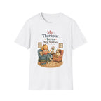 A white short-sleeve crewneck t-shirt featuring a cute cartoon graphic of a woman and her dog in a therapist's office, with the text 'My Therapist Loves My Stories'.