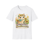 A white short-sleeve crewneck t-shirt featuring a colorful cartoon graphic of a cute orange tabby cat surrounded by yellow sunflowers and a green bow, with the text 'Meet Me In The Sunflowers' printed below.