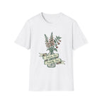 A white short-sleeve crewneck t-shirt featuring a vintage-style graphic of a mason jar filled with pink flowers and green leaves, with a banner reading 'Delicate But Probably Toxic'.