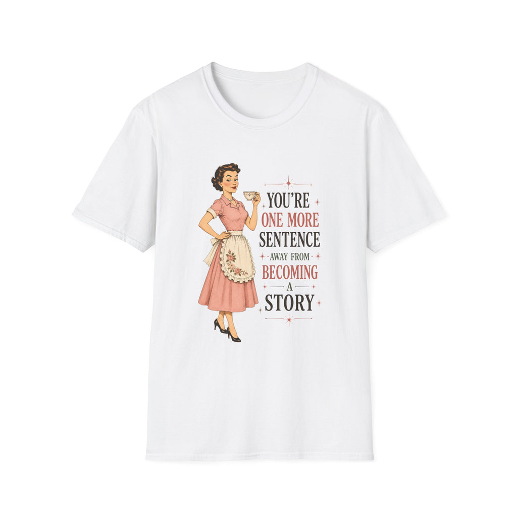 A white short-sleeve crewneck t-shirt featuring a retro-style graphic of a pin-up woman in a pink dress next to the text 'YOU'RE ONE MORE SENTENCE AWAY FROM BECOMING A STORY'.