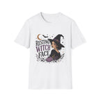A white short-sleeve crewneck t-shirt featuring a Halloween graphic of a witch with the text 'RESTING WITCH FACE' in stylized purple and black lettering, accompanied by a crescent moon, stars, and a pumpkin.