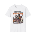 A white short-sleeve crewneck t-shirt featuring a Halloween-themed graphic print on the front. The graphic shows a skeleton sitting in a purple armchair next to a cat, with pumpkins, a cauldron, and the text 'I'M THE PROBLEM' and 'Happy Halloween'.