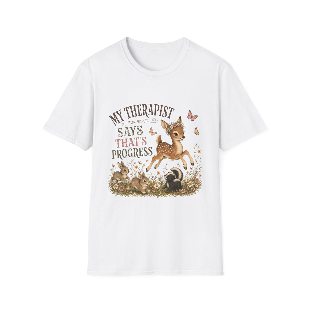 A white short-sleeve crewneck t-shirt featuring a cute woodland graphic of a fawn, rabbits, a skunk, and butterflies with the text 'MY THERAPIST SAYS THAT'S PROGRESS'.